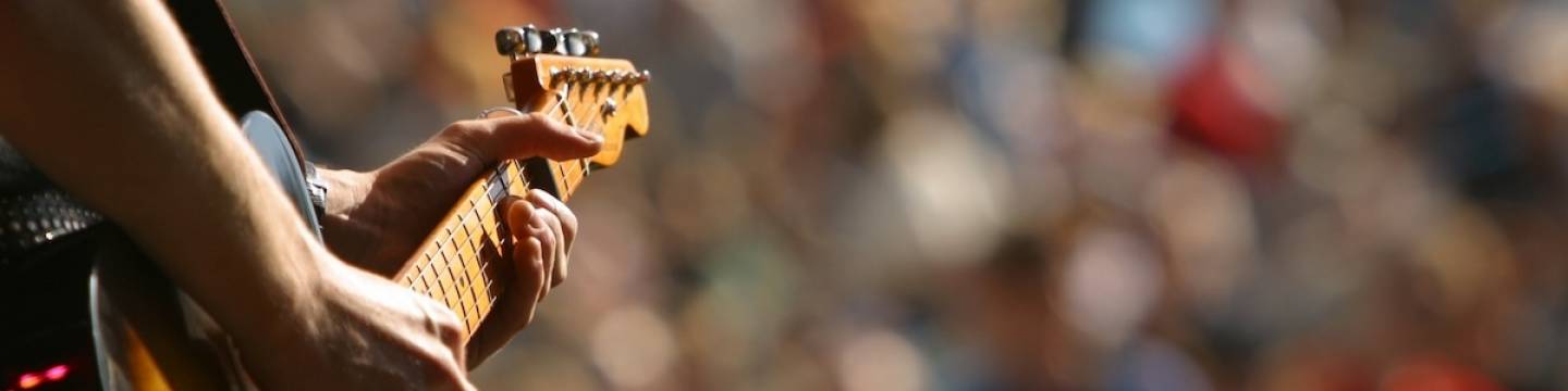 Close up of a guitar during a rock concert